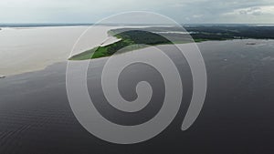 Green peninsula sticking out between the confluence of the Rio negro and Rio Amazon. aerial view