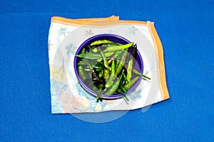 Green Pepper in a bowl on blue background
