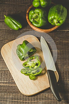 green pepper paprika in a wooden bowl and cut on a wooden board/green pepper paprika in a wooden bowl and cut on a wooden board on