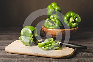 green pepper paprika in a wooden bowl and cut on a wooden board/green pepper paprika in a wooden bowl and cut on a wooden board on