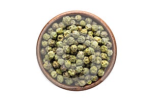 Green peppercorn seeds spice in wooden bowl, isolated on white background. Seasoning top view