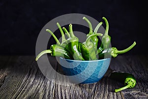 Green peppers on wooden background