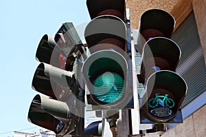 A green permissive light for pedestrians and bicycles shines at the traffic light
