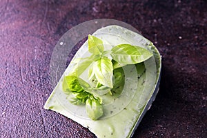 Green pesto cheese and basil leaves on dark rustic table