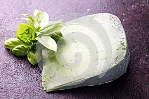 Green pesto cheese and basil leaves on dark rustic table