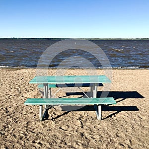 Green picnic table on the beach