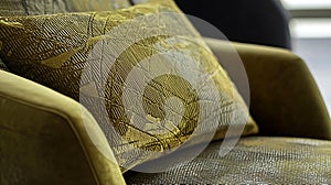 A green pillow with a leaf pattern sits on a chair
