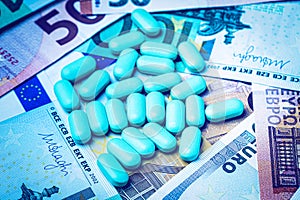 Green pills on the background of euro bills. The concept of the expensive cost of healthcare