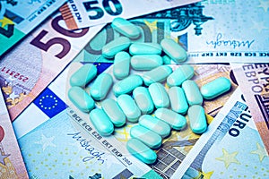 Green pills on the background of one hundred dollar bills. The concept of the expensive cost of healthcare