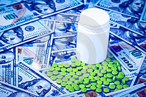Green pills on the background of one hundred dollar bills. The concept of the expensive cost of healthcare or financing medicine.