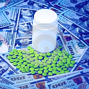 Green pills on the background of one hundred dollar bills. The concept of the expensive cost of healthcare or financing medicine.