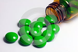 Green pills with a brown bottle