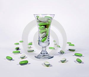 Green pills in a glass photo