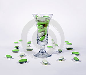 Green pills in a glass