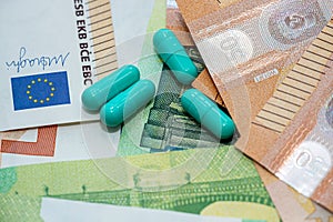 Green pills lie on pile of euro bills background