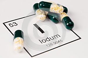 Green pills with mineral I Iodium on a white background with a