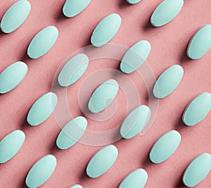 Green pills on pink background