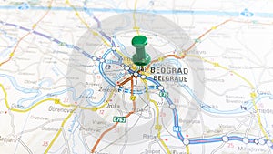 A green pin stuck in Belgrade on a map of Serbia