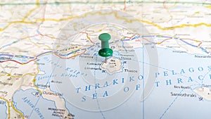 A green pin stuck in the island of Thasos on a map of Greece photo