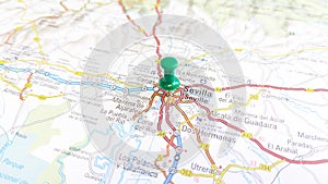 A green pin stuck in a map of Seville Spain