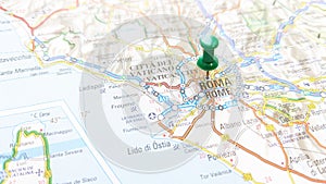 A green pin stuck in Rome on a map of Italy