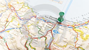 A green pin stuck in San Sebastian on a map of Spain