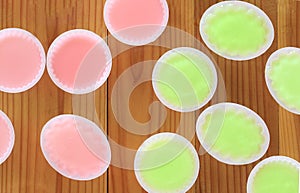 Green and pink jelly on wooden.