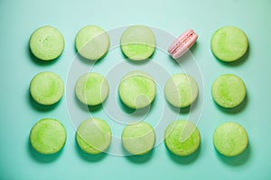 Green and pink macaroons on blue background. Pink is single