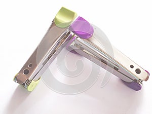Green and pink stapler mags on white background.