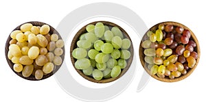 Green, pink and yellow grapes Kishmish. Top view. Grapes in a wooden bowl isolated on white background. Vegetarian or healthy eati