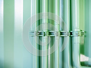 Green pipeline on green shipping container wall