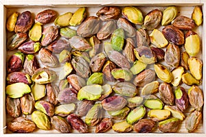 Green pistachio nuts without shell in a wooden box