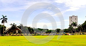 Green plains of the historic Luneta park capturing the famous photo bomber building photo