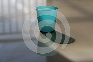 Green plastic cups are exposed to sunlight and form shadows and silhouettes photo