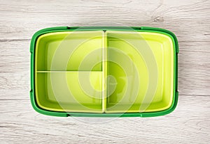 Green plastic food box on the wooden background
