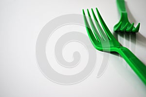 Green plastic forks on white background