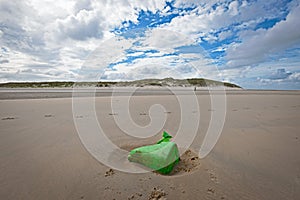 Green plastic garbage on the dutch beach of Vlieland photo
