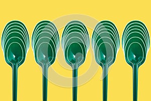 Green plastic spoons in an abstract composition