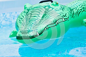 Green plastic toy crocodile in the water