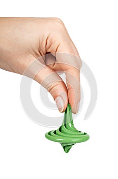 Green plastic toy gyroscope, kid spinner in hand. Isolated on white background