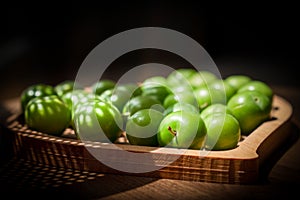 Green plums in a wooden plate photo