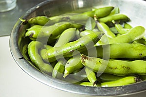 Green pods of vetch broad beans in a bowl