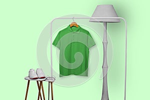 Green polo shirt hanging on rack isolated on plain background