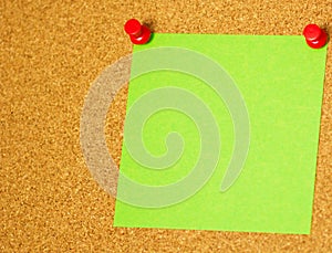 Green post-it on a coarkboard background