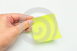 Green post-it note with hand on white background