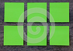 Green post it notes on the wood background