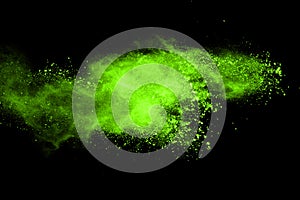 Green powder explosion on black background.