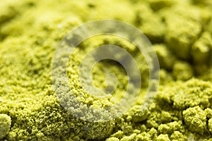 Green powder Japanese matcha tea close-up. The powder contains an admixture of white granules of coconut milk. Matcha latte in dry