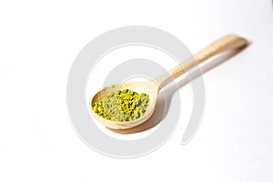 Green powder of Japanese matcha tea in a teaspoon.