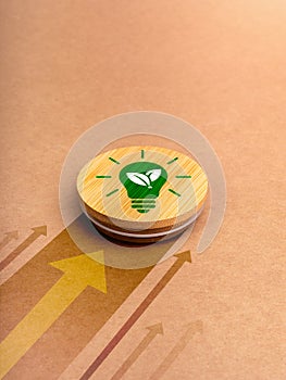 Green power energy icon with lightbulb and leaf symbol on round wood badge moving fast with heading arrows on brown recycled paper